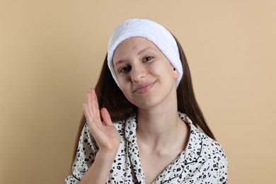 Photo of Teenage girl with acne problem on beige background