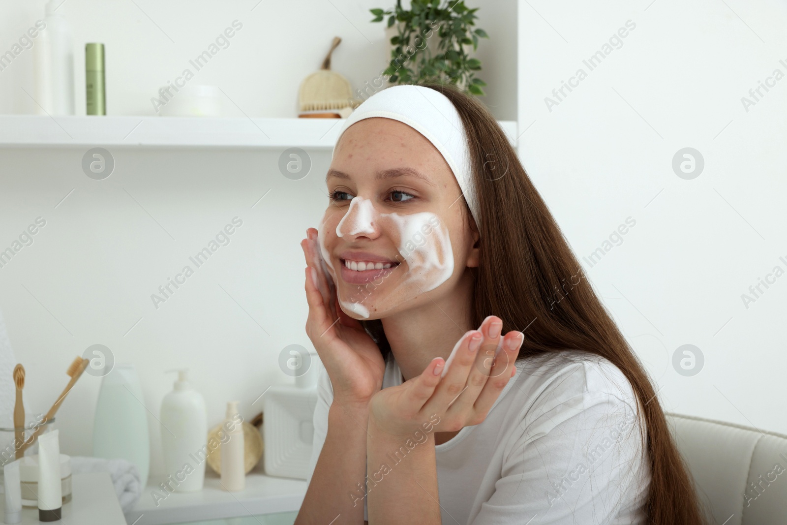 Photo of Teenage girl with cleansing foam on her face at home. Acne treatment