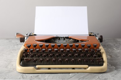 Photo of Vintage typewriter with sheet of paper on grey table