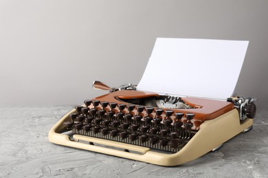 Photo of Vintage typewriter with sheet of paper on grey table