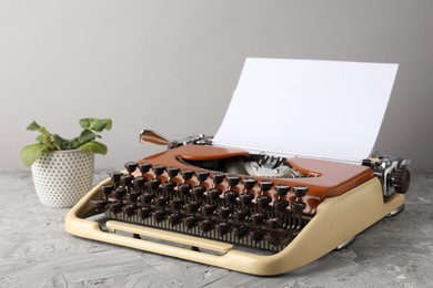 Photo of Vintage typewriter with sheet of paper on grey table