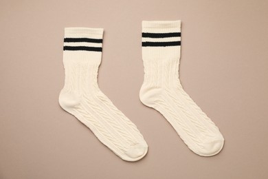 Photo of Pair of soft comfortable socks on brown background, top view