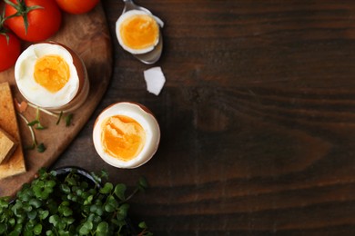 Photo of Soft boiled eggs on wooden table, flat lay. Space for text