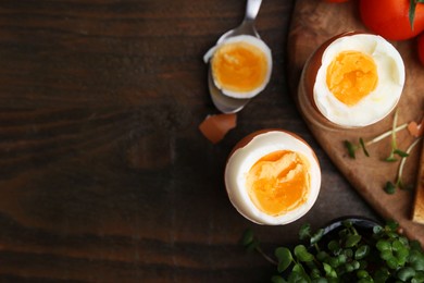 Photo of Soft boiled eggs on wooden table, flat lay. Space for text