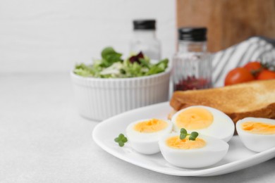 Photo of Hard boiled eggs with bread on light table, closeup. Space for text