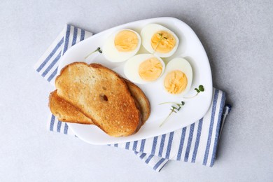 Photo of Hard boiled eggs with bread on light table, top view