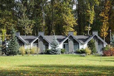 Photo of Hotel buildings and different plants in autumnal park