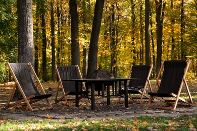 Photo of Picnic table and chairs in beautiful autumnal forest