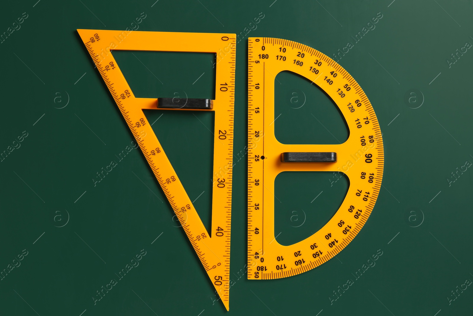 Photo of Protractor and triangle ruler on green chalkboard, top view