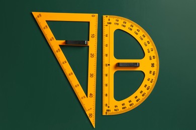 Photo of Protractor and triangle ruler on green chalkboard, top view