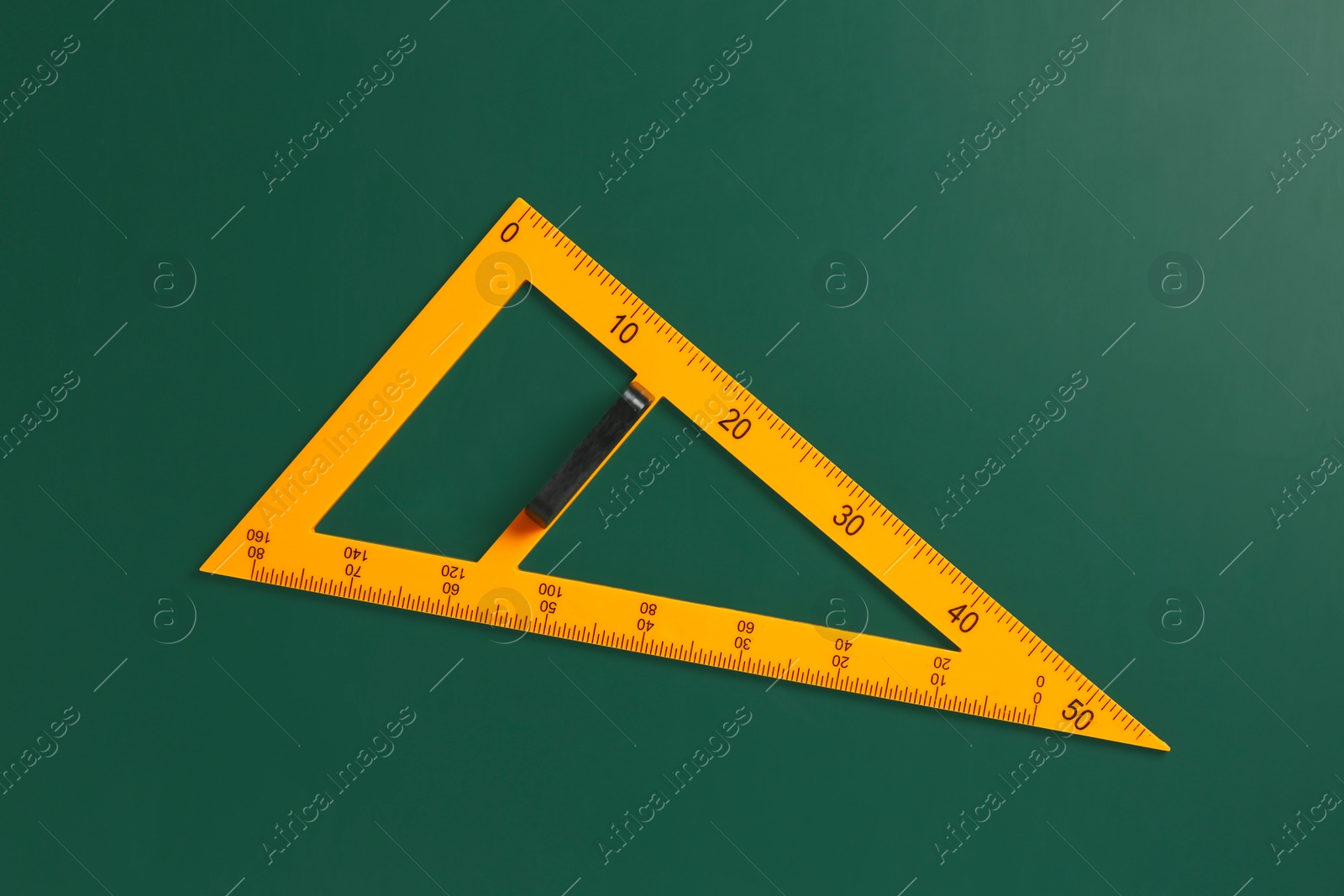 Photo of One triangle ruler on green chalkboard, top view