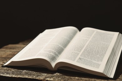 Open Holy Bible in English language on wooden table