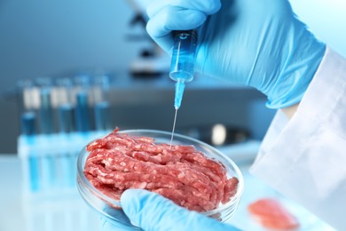 Photo of GMO concept. Scientist injecting something into minced meat in laboratory, closeup.