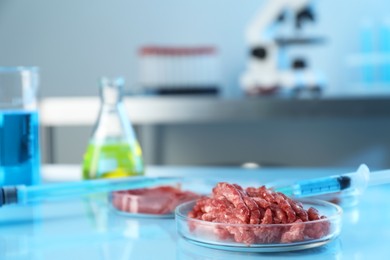 Photo of GMO concept. Minced meat and syringe on table in laboratory. Space for text