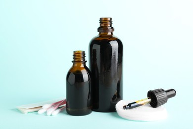 Photo of Topical iodine, cotton pads, swabs and adhesive bandages on light blue background