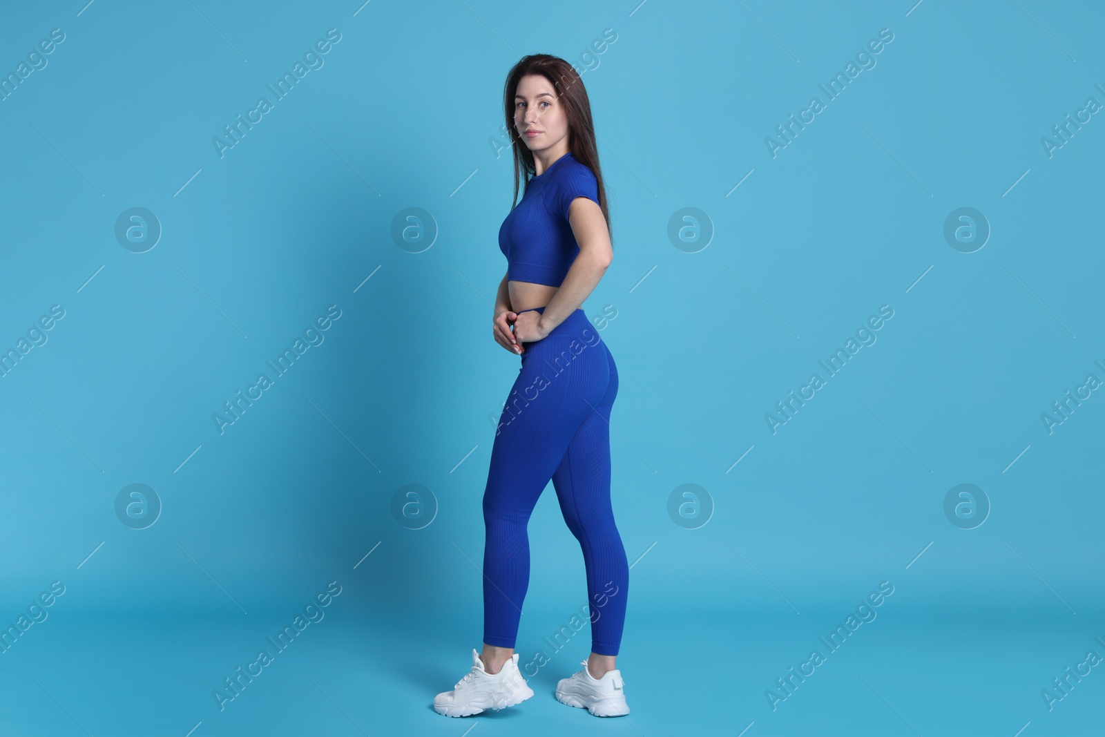 Photo of Woman in sportswear on light blue background