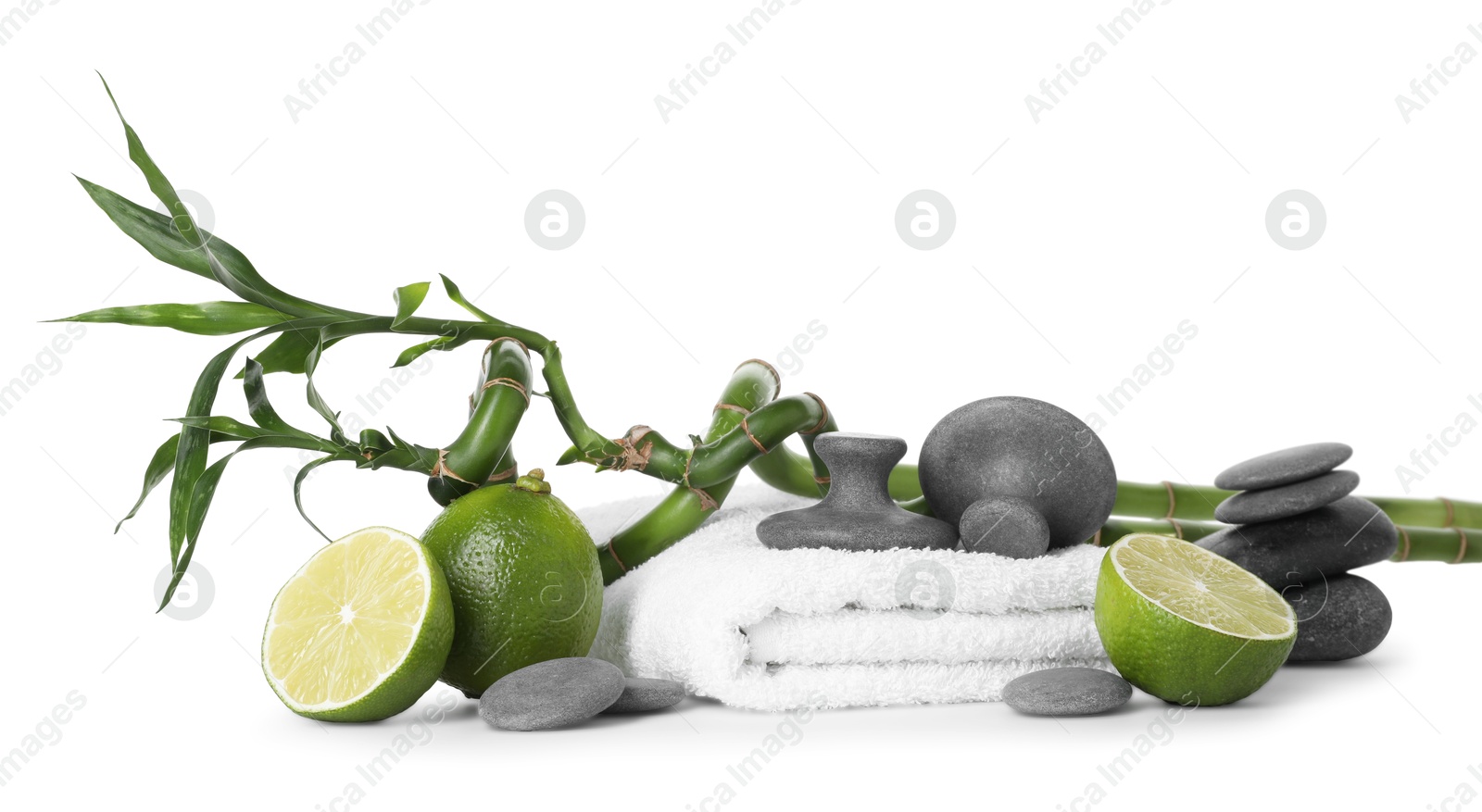 Spa composition with limes, massage stones, towel and bamboo stems isolated on white Photo of Spa composition with limes, massage stones, towel and bamboo stems isolated on white