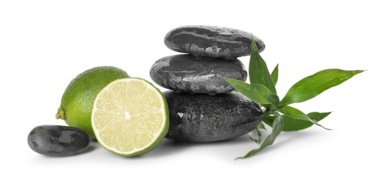 Photo of Spa composition with limes, massage stones and green leaves isolated on white