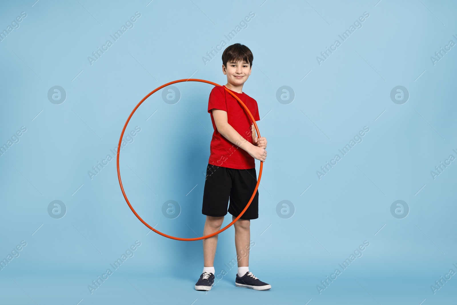 Photo of Boy with hula hoop on light blue background