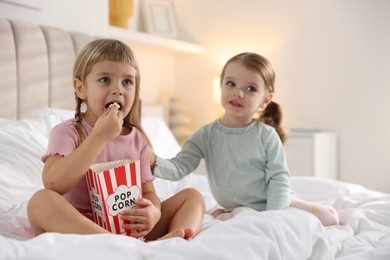 Photo of Cute little sisters spending time together on bed at home, selective focus