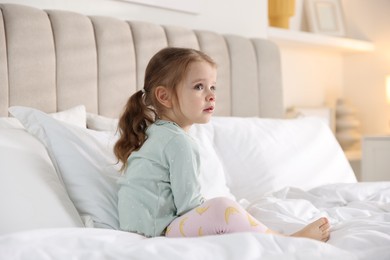 Photo of Cute little girl on bed at home