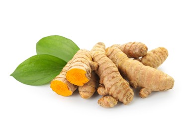 Photo of Raw turmeric roots and green leaves isolated on white