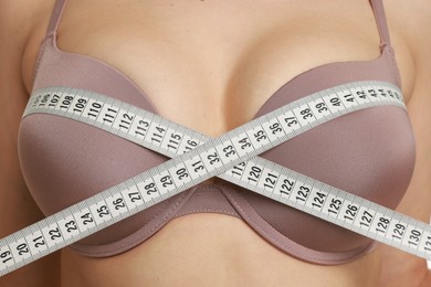 Photo of Woman in beautiful bra measuring breast circumference, closeup