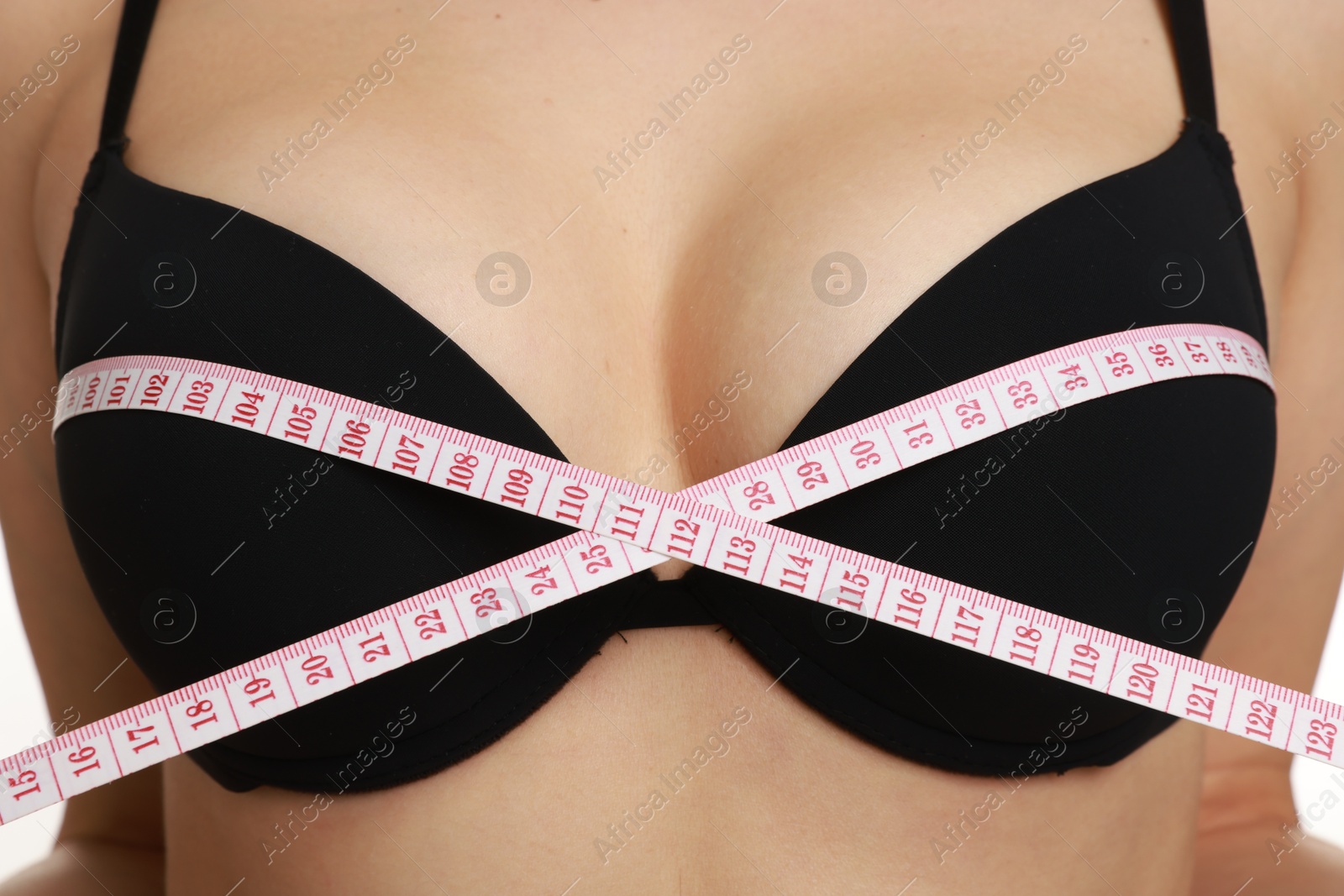 Photo of Woman in beautiful bra measuring breast circumference, closeup