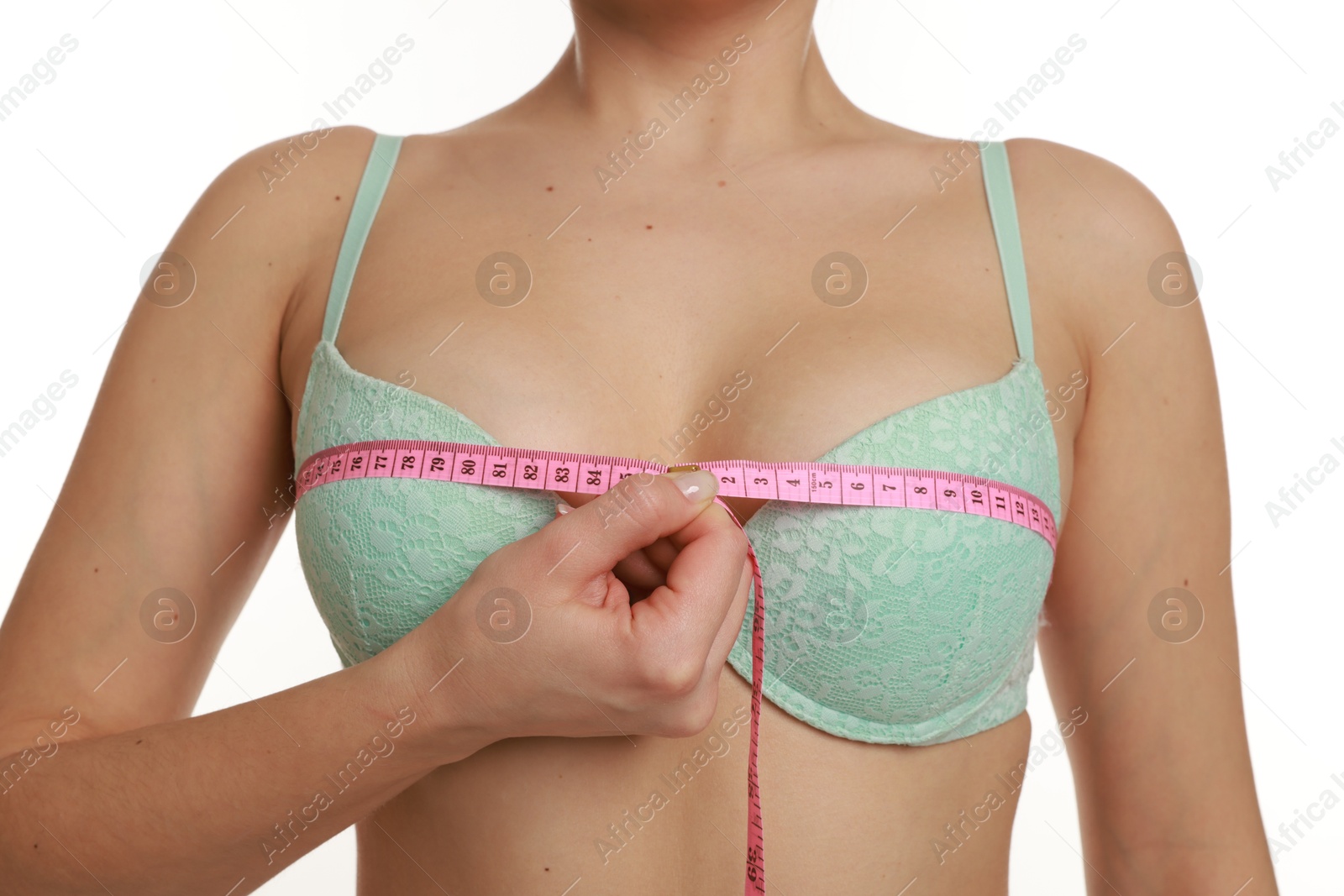 Photo of Woman in beautiful bra measuring breast circumference on white background, closeup