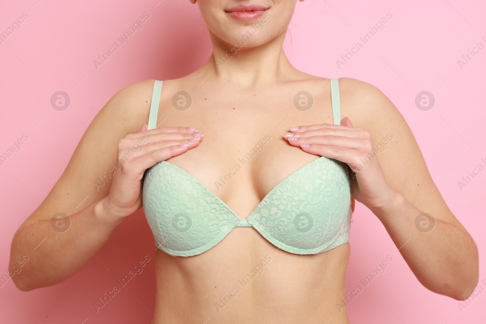 Photo of Woman wearing beautiful bra on pink background, closeup