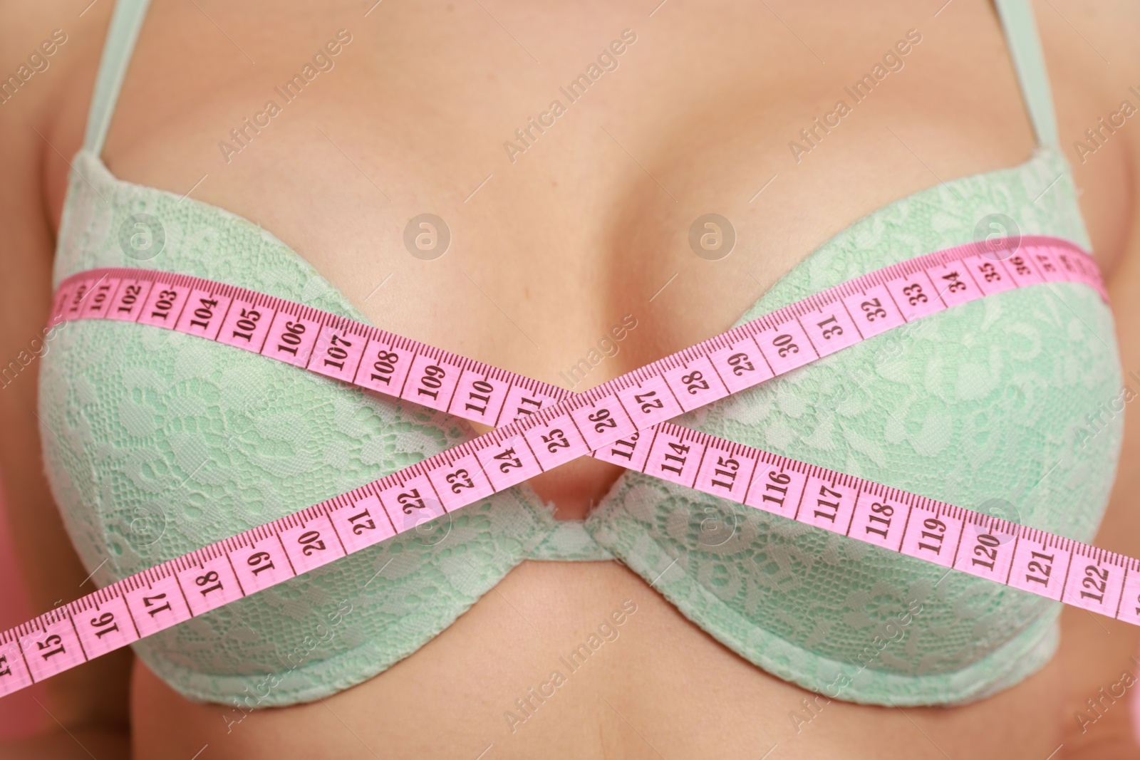 Photo of Woman in beautiful bra measuring breast circumference, closeup