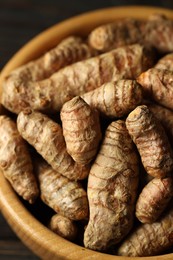 Photo of Tumeric rhizomes in bowl on table, closeup