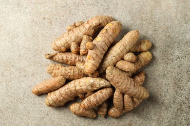 Photo of Pile of tumeric rhizomes on grey table, top view