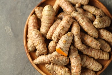 Photo of Raw tumeric rhizomes on grey table, top view