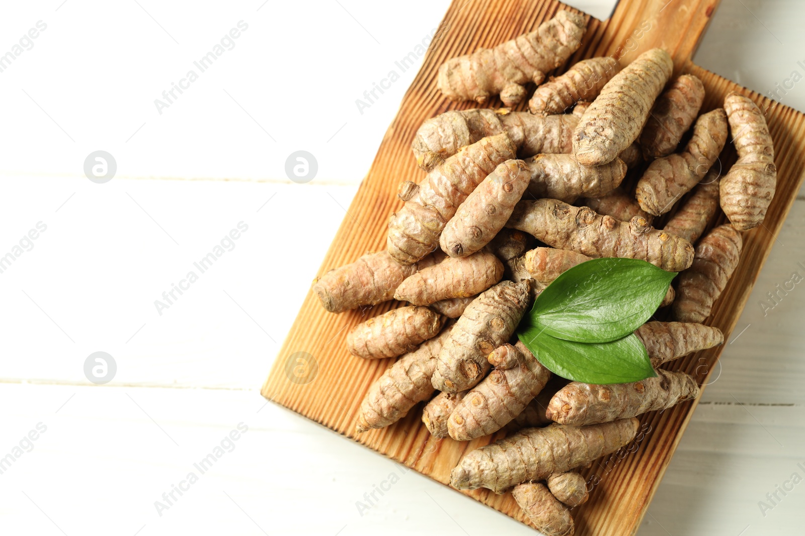 Photo of Tumeric rhizomes on white table, top view