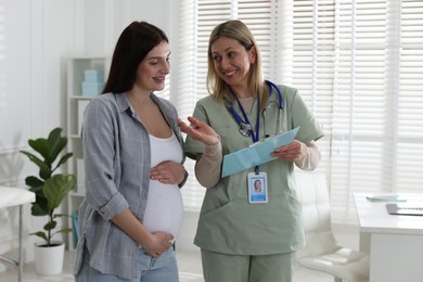 Photo of Pregnant woman having appointment with doctor in clinic