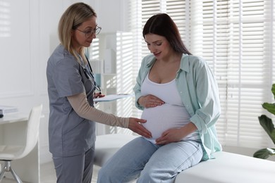 Photo of Pregnant woman having appointment with doctor in clinic