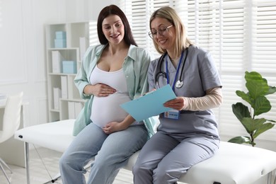 Photo of Pregnant woman having appointment with doctor in clinic