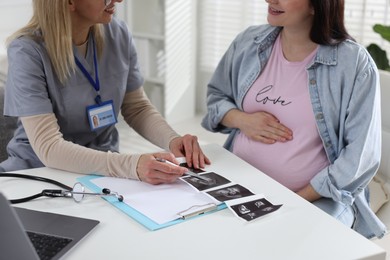 Photo of Pregnant woman having appointment with doctor in clinic, closeup