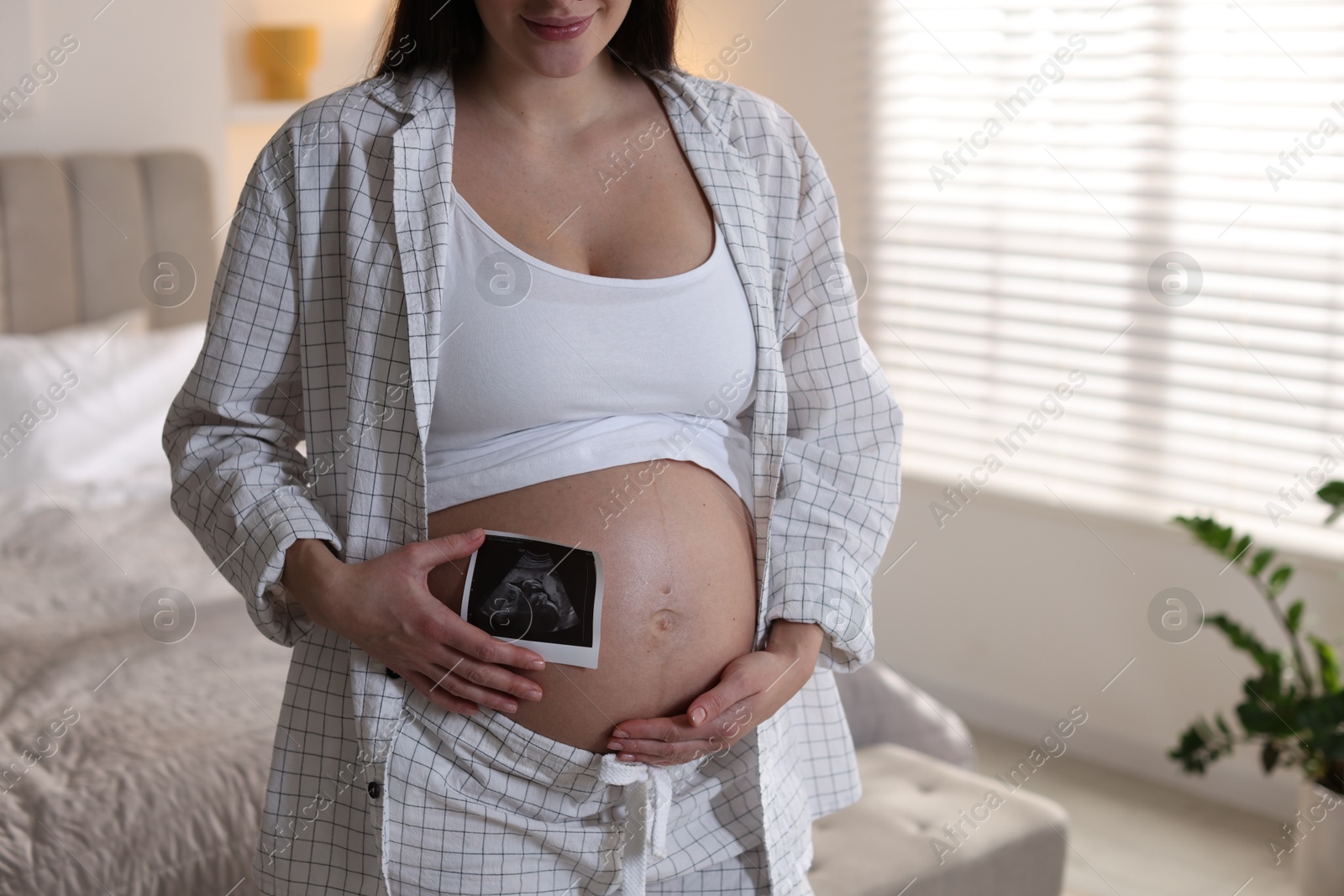 Photo of Pregnant woman with ultrasound scan at home, closeup