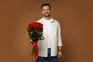 Happy Valentine's Day. Handsome man with bouquet of roses on brown background