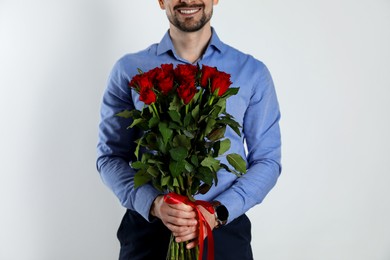 Photo of Happy Valentine's Day. Man with bouquet of roses on white background, closeup