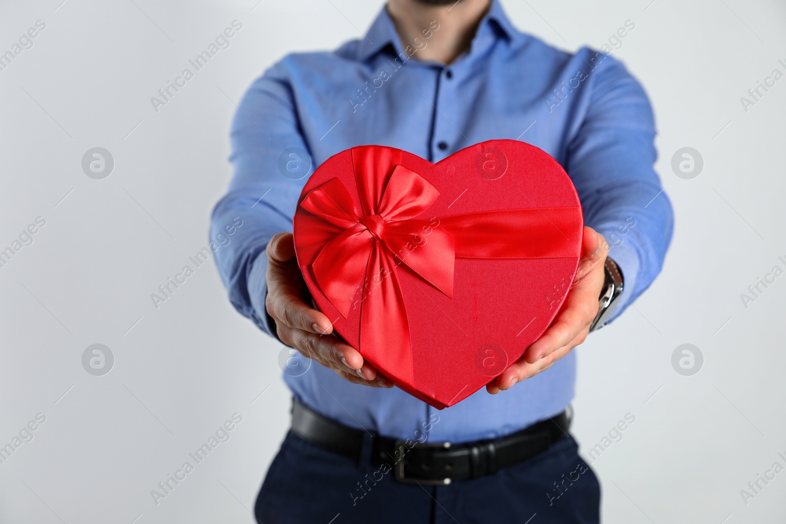 Photo of Happy Valentine's Day. Man with heart shaped gift box on white background, closeup