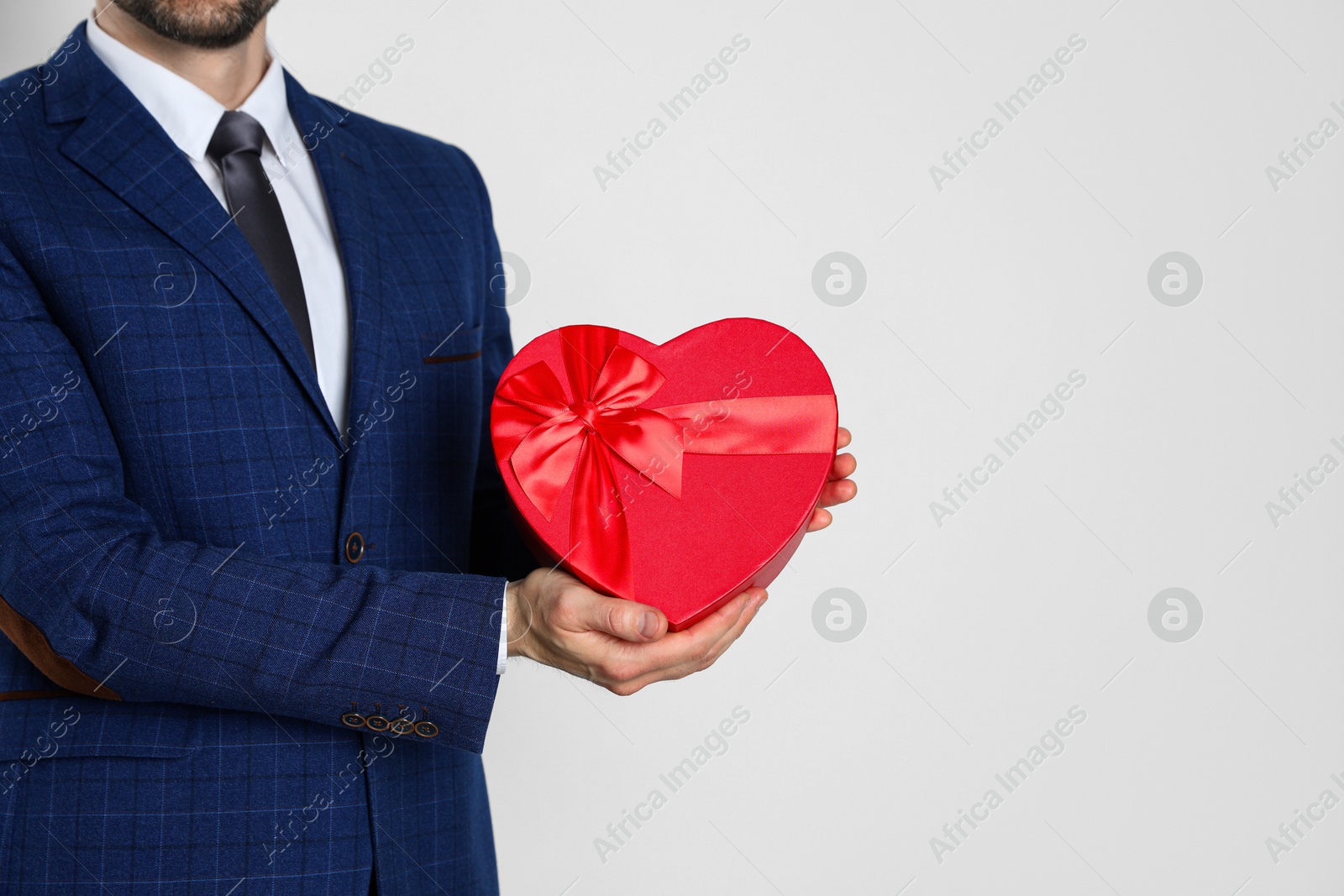 Photo of Happy Valentine's Day. Man with heart shaped gift box on white background, closeup. Space for text