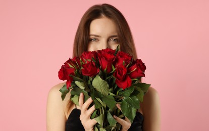 Photo of Happy Valentine's Day. Beautiful woman with bouquet of roses on pink background