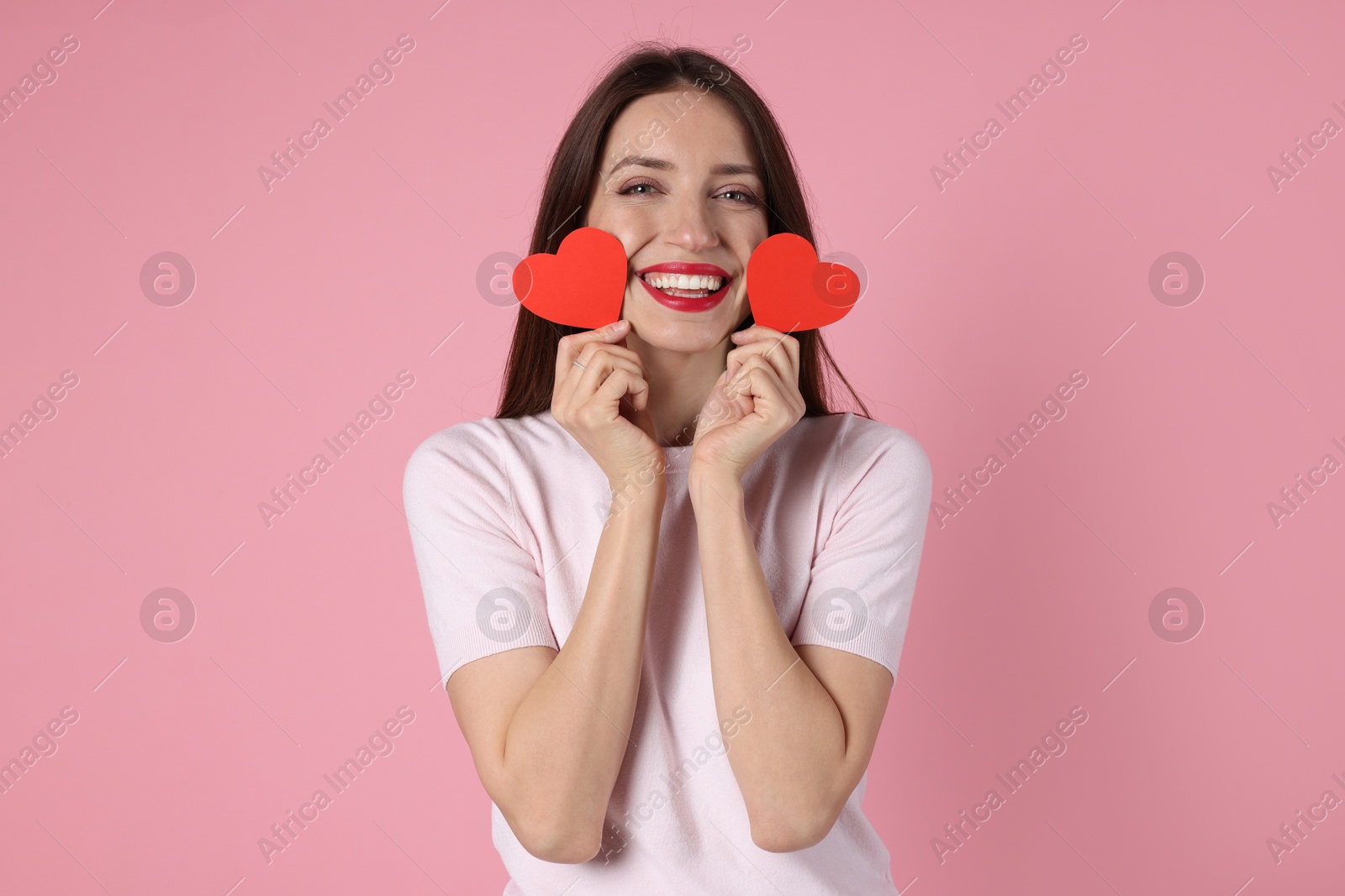 Photo of Happy Valentine's Day. Beautiful woman with paper hearts on pink background