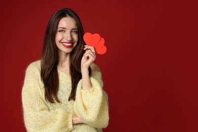 Photo of Happy Valentine's Day. Beautiful woman with paper hearts on red background. Space for text