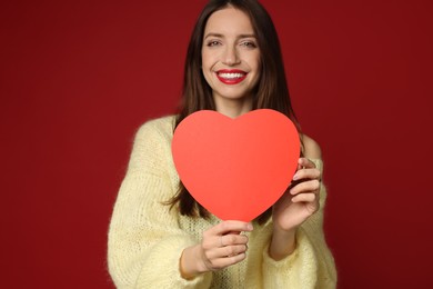 Photo of Happy Valentine's Day. Beautiful woman with paper heart on red background