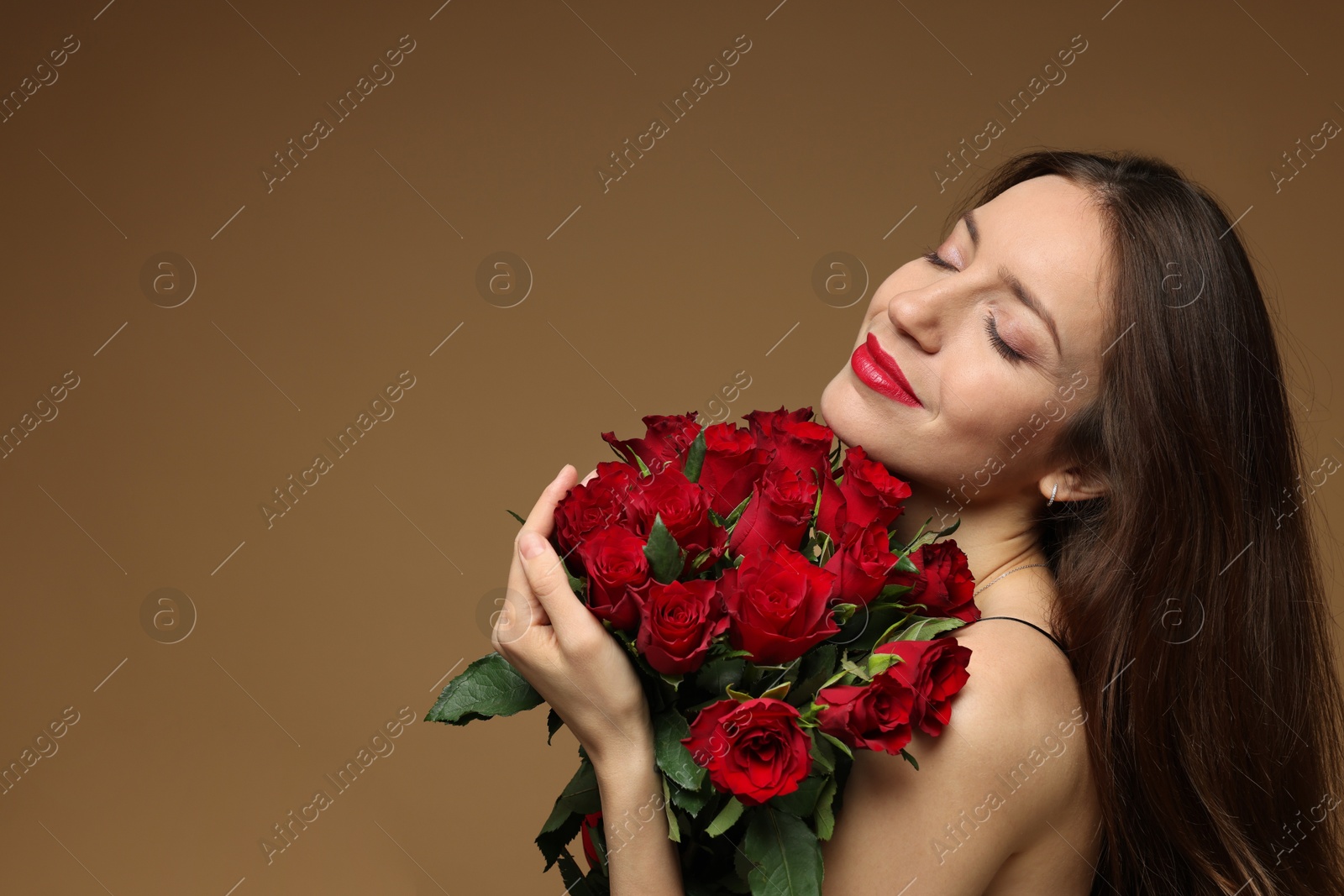 Photo of Happy Valentine's Day. Beautiful woman with bouquet of roses on brown background. Space for text