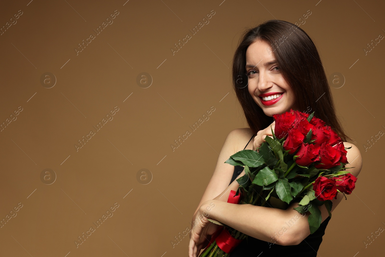 Photo of Happy Valentine's Day. Beautiful woman with bouquet of roses on brown background. Space for text